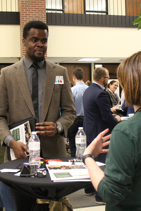 Male student talks to visiting business professionals at the Backpack-to-Briefcase professional networking event.