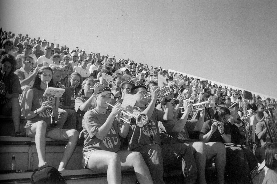 Band members in the bleachers playing their instruments.